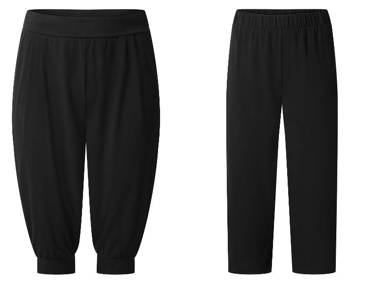 Twee zwarte damesbroeken: één losvallende harembroek en één rechte broek.