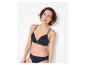 Lachende vrouw in zwarte beha en slip met kanten details.