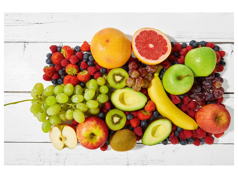 Une variété de fruits, y compris l'avocat, le kiwi, la banane, la pomme, les raisins et les baies.