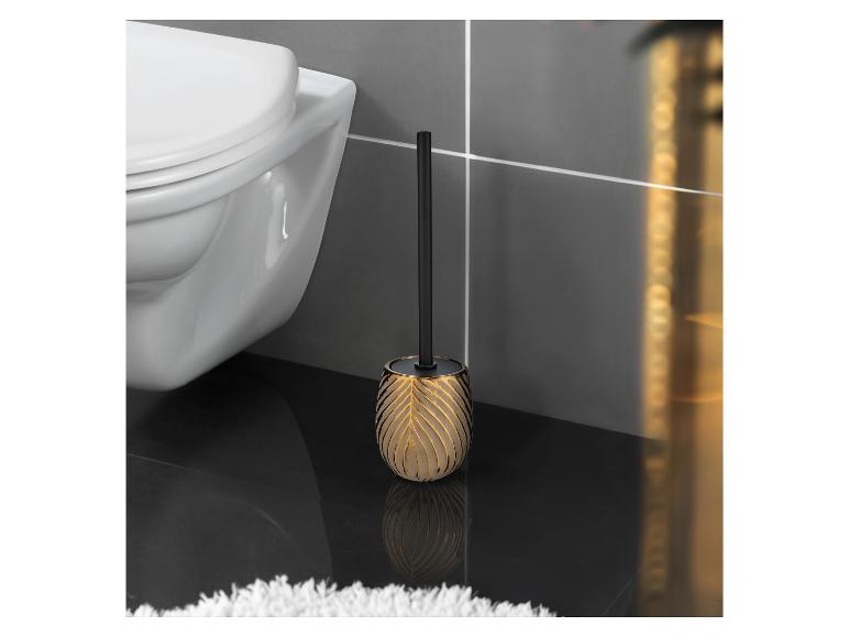 Brosse de toilette dorée avec manche noir.