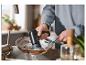 Personne lavant une poêle avec une brosse de nettoyage électrique SilverCrest dans la cuisine.