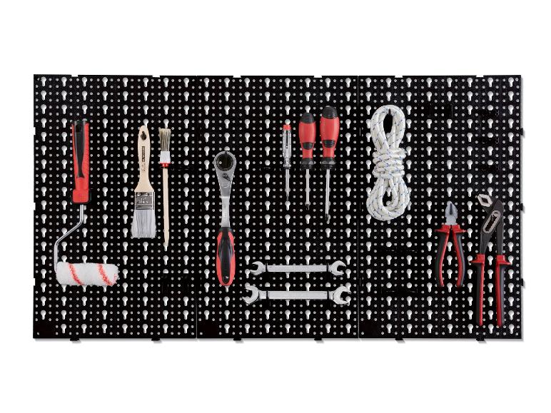 Un mur d'outils noir avec des tournevis, des pinces, un rouleau et une corde.