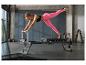 Femme s'entraînant avec un appareil de Pilates dans une salle de sport.