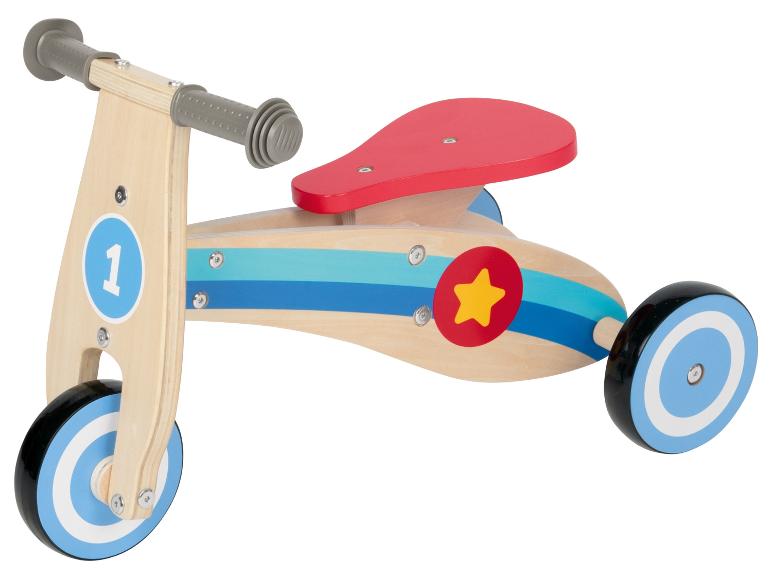 Un vélo d'équilibre en bois pour enfant avec des roues bleues et une selle rouge.