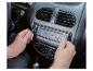 Mains retirant un autoradio de son emplacement dans le tableau de bord d'une voiture.