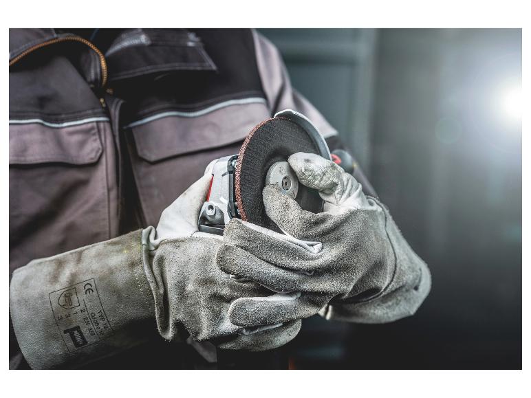 Mains gantées de protection manipulant une meuleuse d'angle avec un disque abrasif.