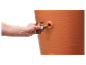 Robinet sur un grand réservoir d'eau terracotta.