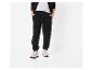 Homme en pantalon de survêtement noir, t-shirt gris et sweat à capuche noir avec des baskets beiges.