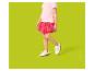 Meisje in roze T-shirt, rode rok en witte sneakers.