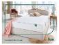 Een wit Fan matras op een beige bedframe.