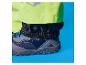 Gros plan du pied d'une personne portant un pantalon de pluie vert fluo et une chaussure bleu foncé.