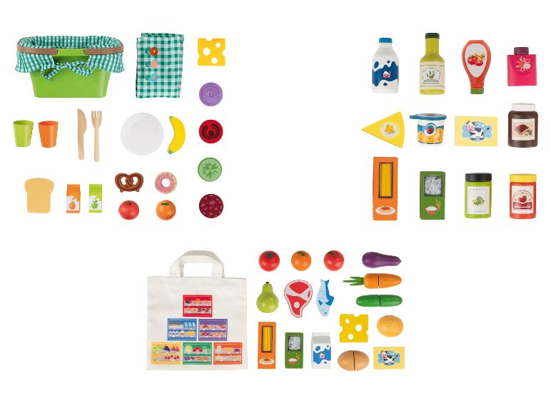 Ensemble de jouets alimentaires et accessoires de pique-nique, comprenant un panier, des couverts et divers aliments.