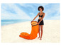 Een vrouw op het strand met een oranje opblaasbare stoel.