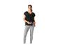 Femme en haut noir et leggings gris, tenant une bouteille d'eau.