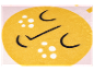 Détail d'un textile jaune à motifs de visage souriant et points blancs.