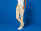 Beige broek met Lidl-print en witte sneakers.