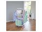 Een wit wasrek met diverse kleding en handdoeken, naast een wasmachine.