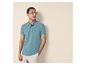 Man in blauwgroene poloshirt en beige korte broek, met zonnebril, kijkt naar rechts.