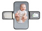 Een baby ligt op een grijs verzorgingskleed met opbergvakken voor luiers en doekjes.
