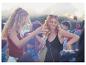 Festivalgangers dansen, bohemian outfits, zomerse sfeer.