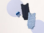 Twee babypakjes met kanten randjes, één blauw met schelpenprint en één zwart.