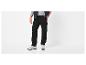 Homme en pantalon cargo noir, t-shirt gris et gilet noir