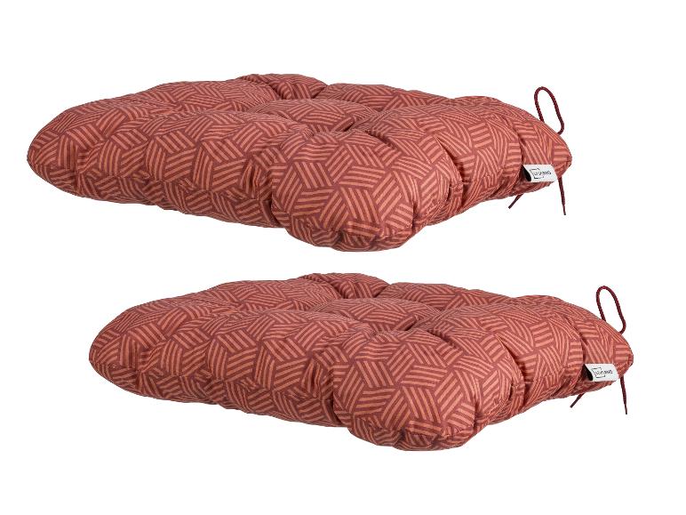 Deux coussins de siège rouges avec un motif géométrique et des attaches.