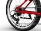 Close-up van het achterwiel van een rode fiets, met de derailleur, cassette en ketting.
