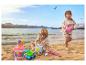 Twee kinderen spelen met strandspeelgoed op het strand, met zee en bergen op de achtergrond.