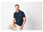 Donkerblauwe polo en beige broek voor heren.