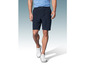 Un homme portant un short bleu foncé et des baskets blanches.