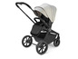 Een zwarte kinderwagen met een beige kap, van het merk Valco Baby.