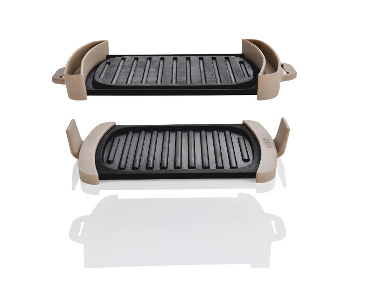 Deux plaques de cuisson noires avec des poignées beiges.