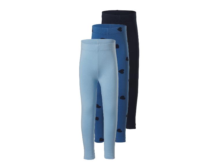 Trois leggings pour filles dans des tons bleus, un avec des cœurs, sur fond blanc.