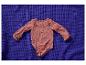 Roze baby romper met hartjes op een blauwe deken