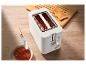 Een witte Cuisinart broodrooster met geroosterd brood en jam.