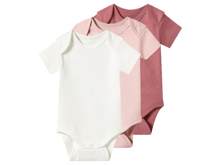 Trois bodys de bébé à manches courtes en blanc, rose clair et rose foncé.