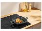 Grillpan met gegrilde kip en groenten op een inductiekookplaat