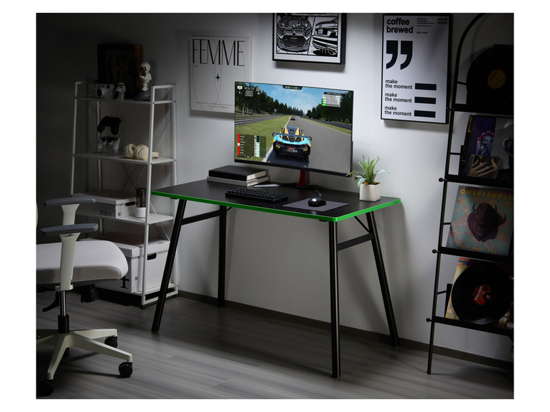 Un bureau de jeu noir avec une bordure verte, un moniteur d'ordinateur, un clavier et une souris.
