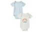Twee babypakjes, één blauw en één wit met een regenboogprint.
