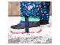 Bottes d'hiver noires avec des accents roses sur la neige.