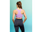 Vrouw in een paarse sportbeha en zwarte leggings.