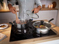 Deux casseroles Tefal avec des couvercles en verre sur une plaque à induction.