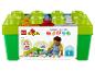 Boîte de rangement LEGO Duplo avec des briques colorées et un enfant qui joue.