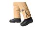 Gros plan d'une personne portant un pantalon de ski beige et des bottes noires.
