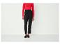 Pantalon noir avec un chemisier rouge et des mocassins noirs à franges.