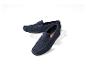 Twee marineblauwe suède herenloafers op een witte sokkel.