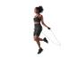 Femme en brassière de sport noire et short cycliste sautant à la corde.