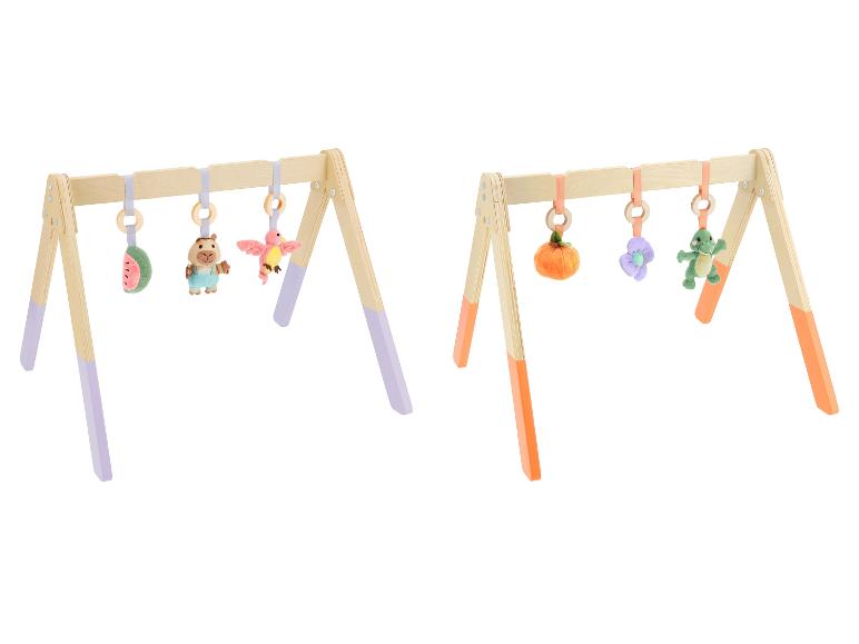 Twee houten babygyms met hangende pluchen speeltjes, één met paarse accenten, de andere met oranje.