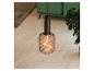 Hanglamp met filamentlamp in een woonkamer met een groene bank en plant.